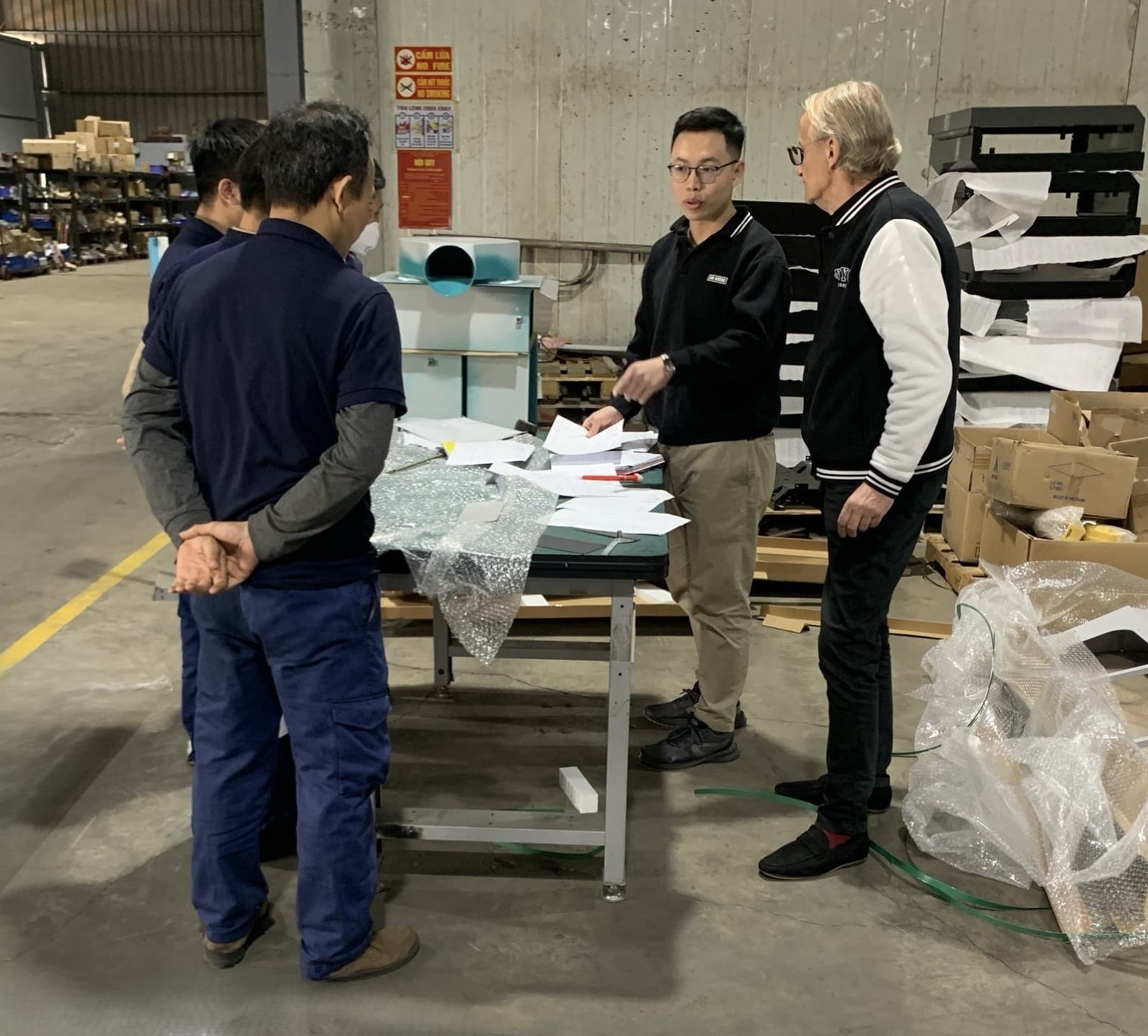 Lekker team reviewing production documents with a client on the factory floor